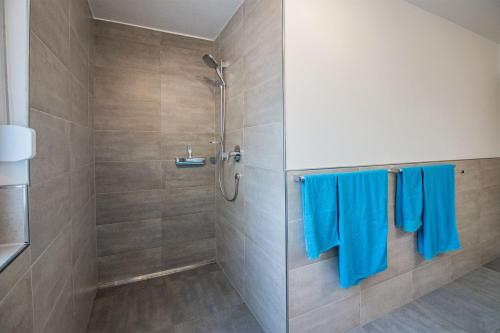 a bathroom with a shower with blue towels at Paradieshof in Lautenbach