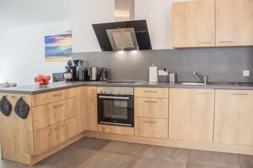 a kitchen with wooden cabinets and a stove top oven at Paradieshof in Lautenbach
