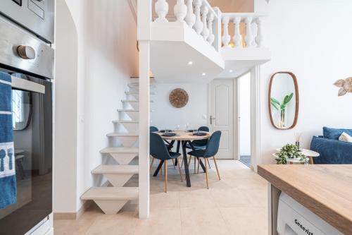 une cuisine et une salle à manger avec un escalier en colimaçon et une table dans l'établissement 1 LONGCHAMP - Joli appartement - Carre d Or - Climatise, à Nice