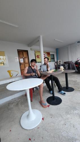 two men sitting at tables in a room at No.9 Hostel kanchanaburi in Ban Don Rak