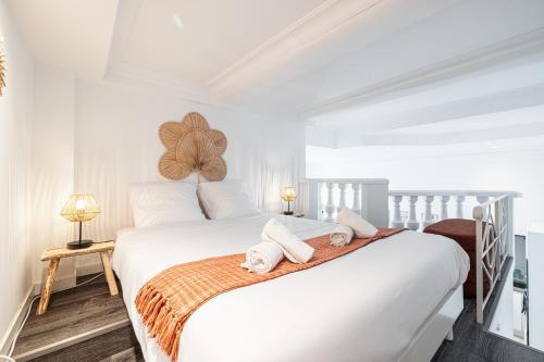 une chambre avec un lit blanc avec des serviettes dessus dans l'établissement 1 LONGCHAMP - Joli appartement - Carre d Or - Climatise, à Nice
