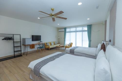 a bedroom with two beds and a ceiling fan at Sea Passion Hotel in Koror
