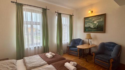 sypialnia z łóżkiem, dwoma krzesłami i stołem w obiekcie HOTEL - Pałac Słonowice w mieście Brzeżno