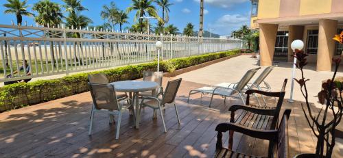 a patio with a table and chairs and a fence at Verdadeiro pé na areia TOP in Santos