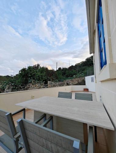 a table and chairs on the balcony of a house at Hilltop Hideaway in Cospicua