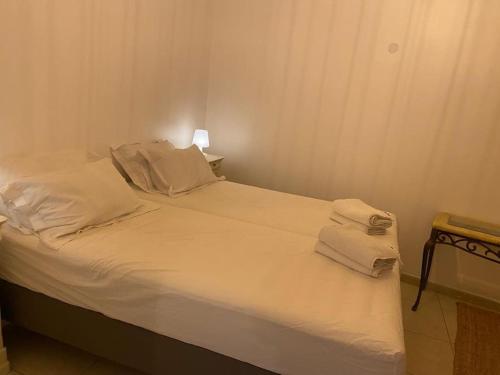 un lit avec des draps blancs et des oreillers dans une chambre dans l'établissement Maisonnette pour 4 pers piscine de mai à sept 2hrs par jour, à Dagneux