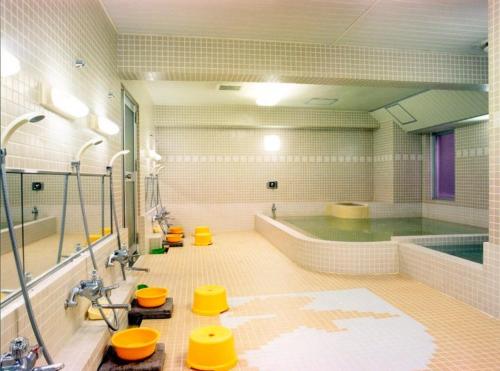 a large bathroom with a swimming pool and a tub at Hotel Hashimoto in Sapporo
