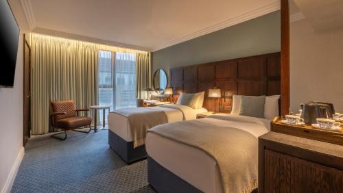 a hotel room with two beds and a window at Clayton Hotel Cambridge in Cambridge