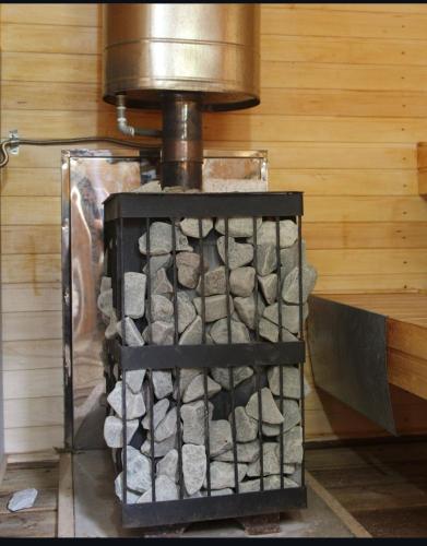 a wood stove with a pile of fire ashes at Green Hill Glamping in Almaty