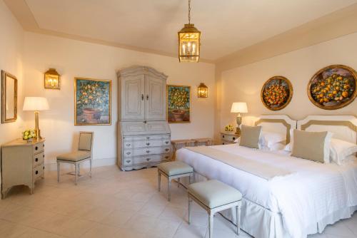 a bedroom with a large bed and two chairs at Wine Resort Dievole in Vagliagli