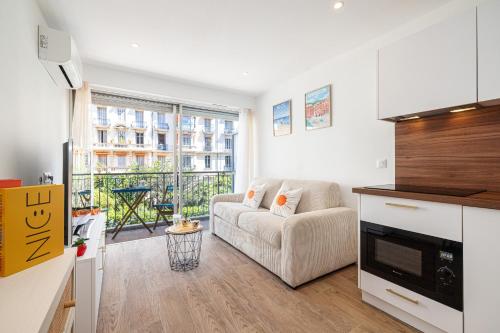 un salon avec un canapé et une cuisine dans l'établissement 10 ORANGERS - Magnifique studio climatise - Les Clementines, à Nice