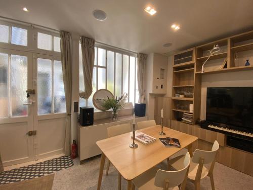 un salon avec une table en bois et une télévision dans l'établissement Calm & Charming Atelier in Paris, à Paris