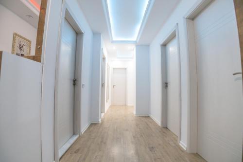 a hallway with white walls and a skylight at Dodona ApartHotel in Prishtina in Pristina