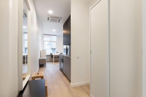a kitchen and dining room with white walls and wooden floors at Hook Studios Vilnius Old Town in Vilnius