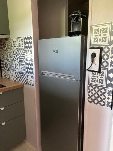 - un réfrigérateur en acier inoxydable dans une cuisine revêtue de carrelage dans l'établissement Joli Studio Gréoux Les Bains, à Gréoux-les-Bains