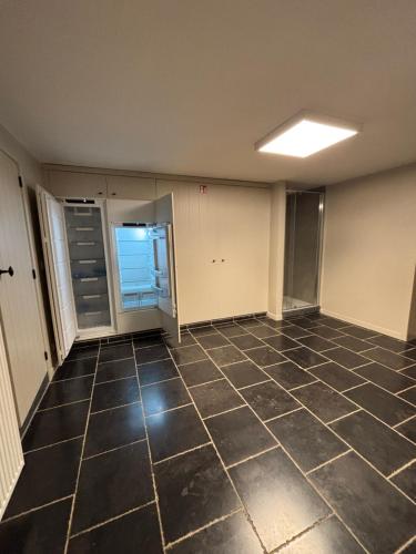 an empty room with a tiled floor at 't Urbain - Vakantiewoning in Oudenaarde