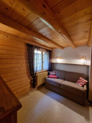 un salon avec un canapé et une fenêtre dans l'établissement Lou R'bat Pays, au Grand-Bornand