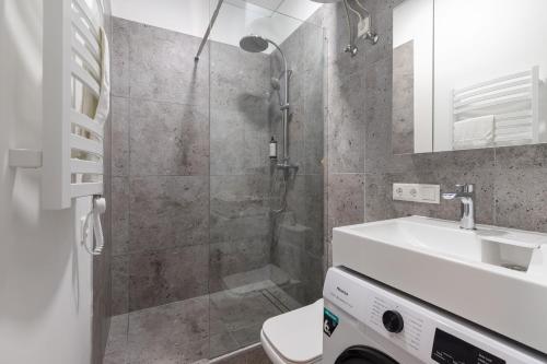 a bathroom with a shower and a sink and a toilet at Hook Studios Vilnius Old Town in Vilnius