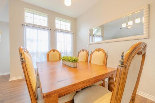a dining room with a wooden table and chairs at Oasis - Indoor Swimming Pool in The Colony