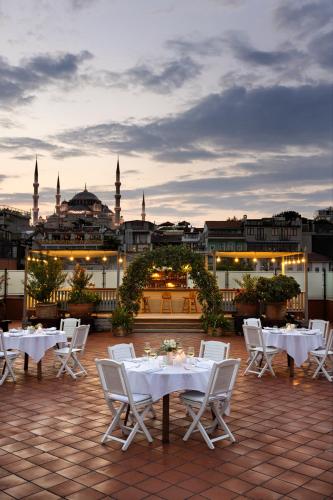 a patio with white tables and chairs on a roof at Armada Istanbul Old City Hotel in Istanbul