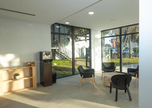 a lobby with chairs and a table and windows at Flag Hotel Lisboa Sintra in Sintra