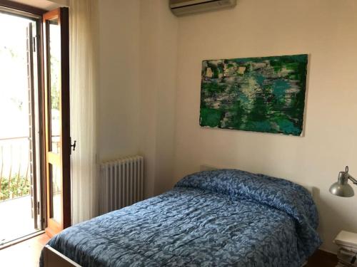 a bedroom with a bed and a painting on the wall at Casa delle Sirene in Perugia