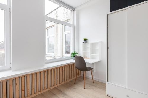 a desk and a chair in a room with a window at Hook Studios Vilnius Old Town in Vilnius