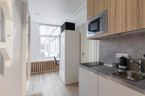 a kitchen with a sink and a microwave at Hook Studios Vilnius Old Town in Vilnius