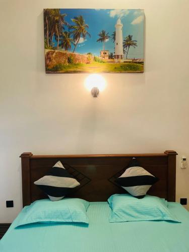 a bedroom with a bed with a light and a lighthouse at Villa Amorino in Galle