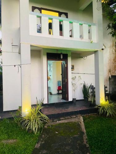 a house with a balcony and a door at Villa Amorino in Galle