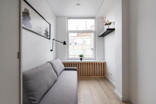 a living room with a couch and a window at Hook Studios Vilnius Old Town in Vilnius