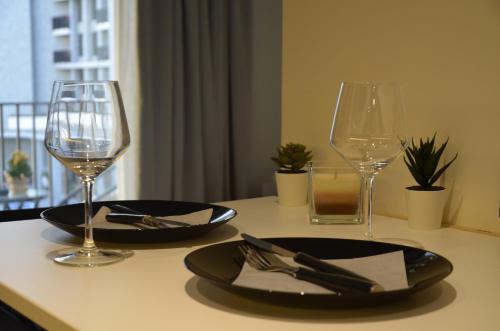 a table with two glasses and a plate and fork and knife at Waterfront Retreat with Garage and Balcony in Belgrade