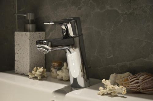 a faucet sitting on top of a bathroom sink at Waterfront Retreat with Garage and Balcony in Belgrade