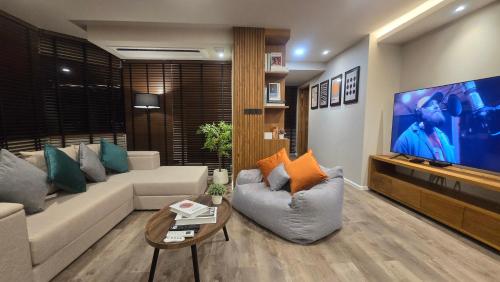 a living room with a couch and a tv at ARMO Nimman 2 Suite in Chiang Mai