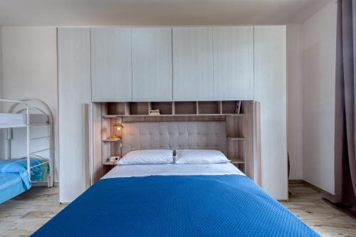 a bedroom with a large blue bed with cabinets at Anghelos in Lizzanello