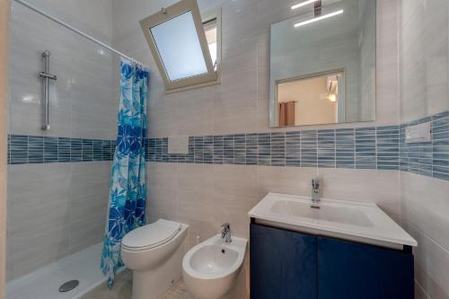 a bathroom with a toilet and a sink and a mirror at Anghelos in Lizzanello