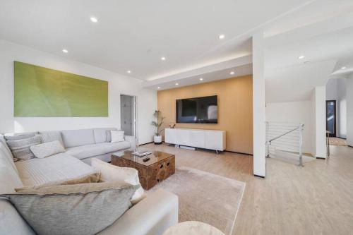a living room with a white couch and a tv at Wander Malibu Canyon in Malibu Beach