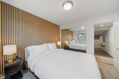 a bedroom with a large white bed and a room with a bed sqor at Wander Malibu Canyon in Malibu Beach