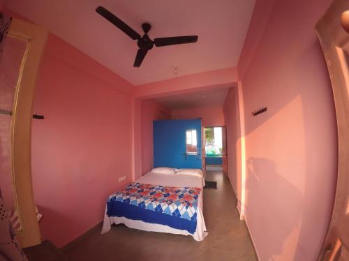 a bedroom with a bed and a ceiling fan at Om Ganesh Guest House Cliffside in Arambol