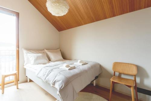 a bedroom with a bed with a wooden ceiling and a chair at Stay North - Joiku - Winter Pines in Äkäslompolo