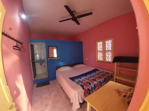 a bedroom with a bed and a ceiling fan at Om Ganesh Guest House Cliffside in Arambol