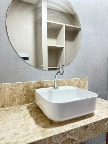 a white sink in a bathroom with a mirror at Charme D'Maria Pousada in Barreirinhas