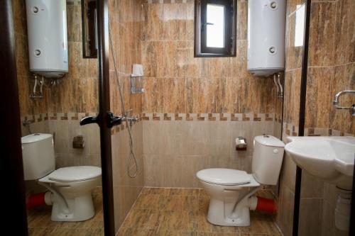 a bathroom with two toilets and a sink and a shower at Бялата къща in Zlatograd