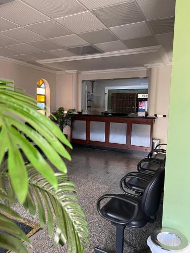 a waiting room with four chairs and a mirror at Hotel Muller in Mariana