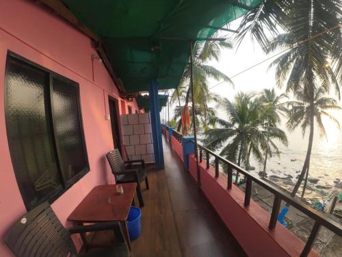 a balcony of a restaurant with a view of the beach at Om Ganesh Guest House Cliffside in Arambol