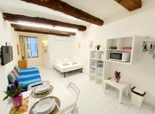 - un grand salon blanc avec une table et des chaises dans l'établissement Studio au coeur de Toulon - proche du port, à Toulon