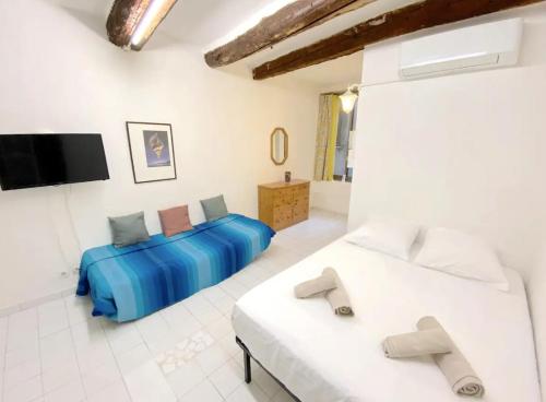 une chambre avec deux lits et une télévision à écran plat dans l'établissement Studio au coeur de Toulon - proche du port, à Toulon