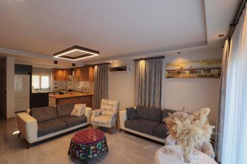 a living room with two couches and a kitchen at Adrasan Villa Adrasya in Olympos