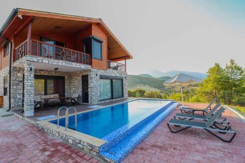a villa with a swimming pool and a house at Adrasan Villa Adrasya in Olympos