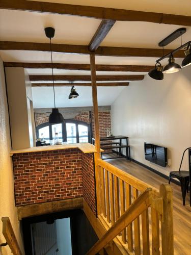 Cette chambre est dotée d'un escalier et d'un mur en briques. dans l'établissement La Tannerie des Spaens, à Tramayes